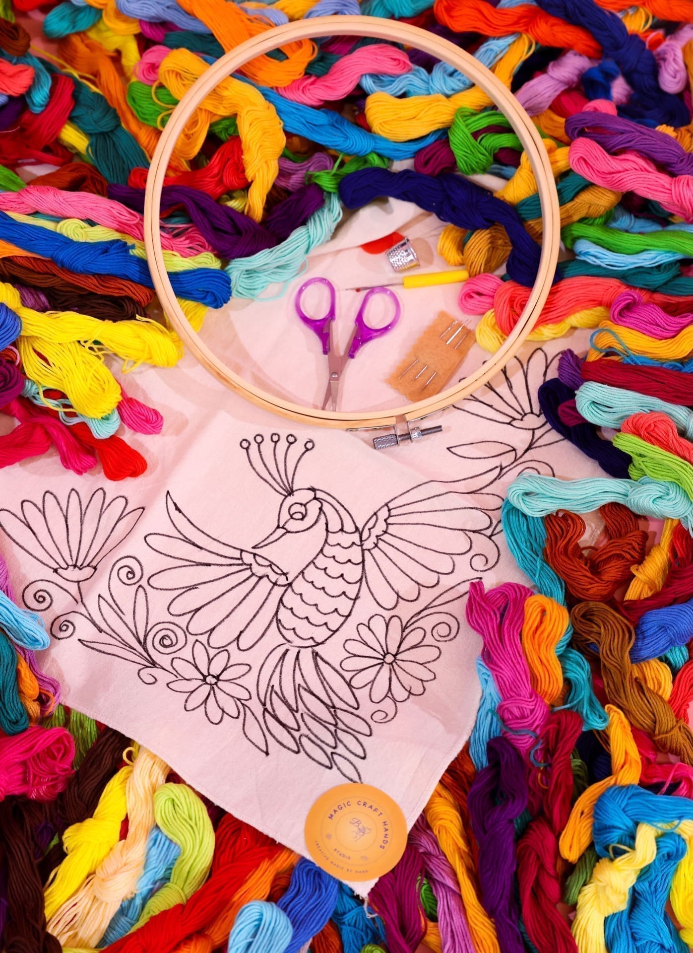 A photo of supplies for many embroidery craft kits, spread across a table.